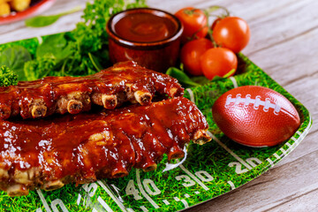 Pork ribs with barbecue sauce on black stone board. Top view.