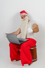 Santa Claus sits at his desk and works at the computer.