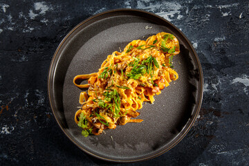 Fettuccine pasta with bacon or meat is on the plate