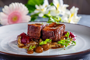 Grilled beef with mushrooms, mashed potatoes and beetroot sauce is on the plate