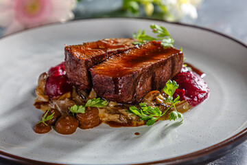 Grilled beef with mushrooms, mashed potatoes and beetroot sauce is on the plate
