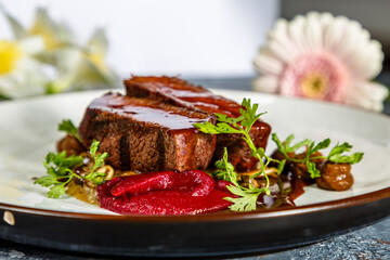 Grilled beef with mushrooms, mashed potatoes and beetroot sauce is on the plate