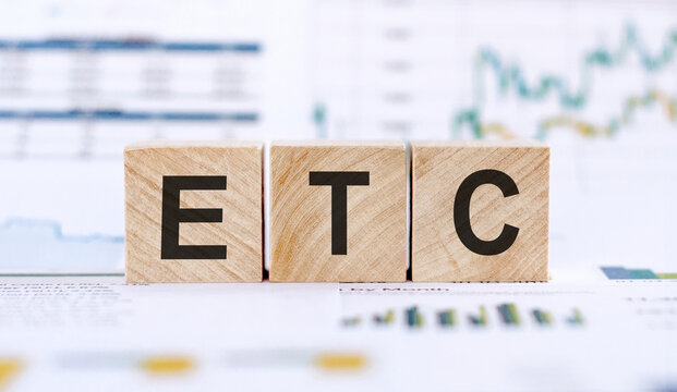 Alphabet letter in word ETC (abbreviation of et cetera) on financial graphs background