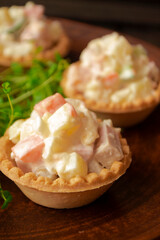 Fototapeta na wymiar Tartlet with russian salad olivier for catering, vertical image