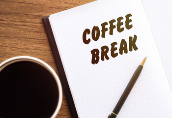 Cup of coffee, notepad with text coffee break on wooden background.