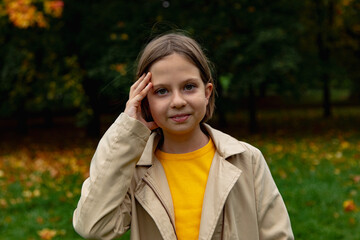 adorable little girl with autumn leaves in the park
