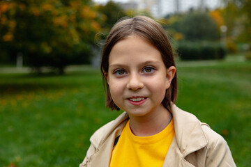adorable little girl with autumn leaves in the park