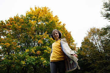 adorable little girl with autumn leaves in the park