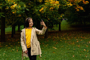 season and people concept .happy girl taking selfie at autumn park