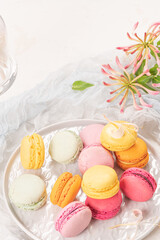 Colorful french macaroon cakes. Macaroons with jasmine flowers on white table background. Selective focus