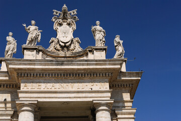 Fototapeta na wymiar Detail of Statues and Vatican coat of arms on St Peters piazza colonnades