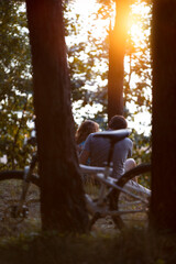 Fototapeta premium Couple of lovers with a bicycle on the evening edge of the forest
