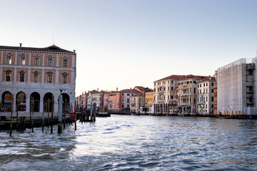 Views of Venetian architecture and buildings alongside the Grand Canal against a pastel sunset sky
