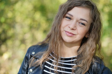 Close up of attractive young woman posing in wood. Charming female photographed on camera, standing in forest.