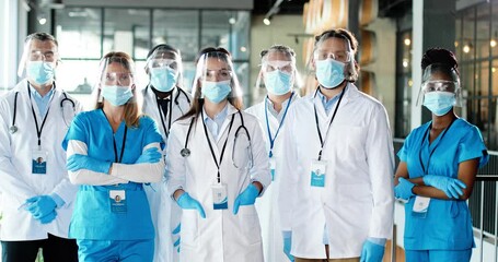 Portrait of team of mixed-races team of professional males and females doctors in hospital. International group of medics in medical masks. Multi ethnic physicians in coronavirus protection in clinic. - Powered by Adobe