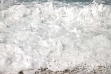 Powerful sea waves crushing on a beach. Waves breaking on the shore. Coastline. Waves with white water spray and foam. Sandy ocean beach at summer. Deep blue sea. Wonderful nature.