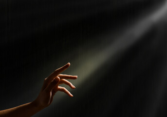 woman's hand reaches for the light rays