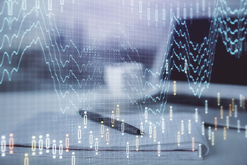 Double exposure of financial graph drawings and desk with open notebook background. Concept of forex market