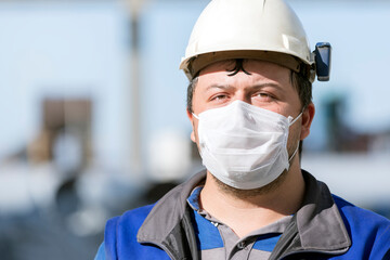 The worker is using protective face mask to protect himself from covid-19. Coronaviruses can cause colds with major symptoms, such as fever, and a sore throat from swollen adenoids.