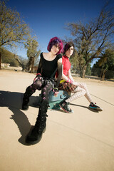 Two Punk Girls Sitting on Suitcases