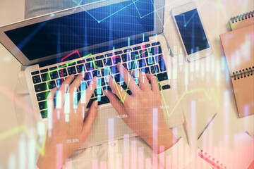 Double exposure of woman hands working on computer and forex chart hologram drawing. Top View. Financial analysis concept.