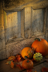Pumpkins, broom and gourds at the door 