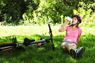 Teenage girl resting in a park with a bicycle