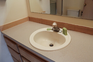 beige bathroom counter old finishes and green soap