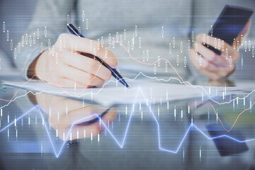Double exposure of forex chart sketch hologram and woman holding and using a mobile device. Financial market concept.