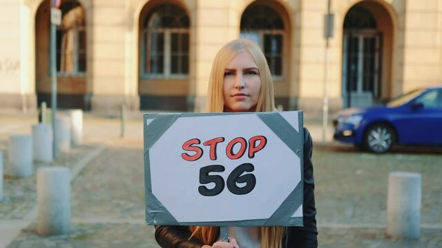 Young woman protesting against 5G internet by walking on the street with steamer.