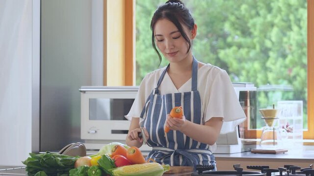 キッチンで料理をする若い女性