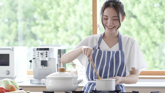 キッチンで料理をする若い女性