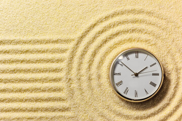 Old watch on surface of golden sand