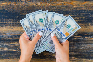 Business concept on wooden background flat lay. woman counting money.