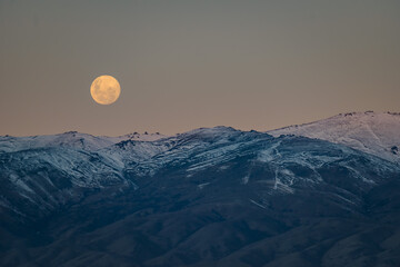 Moonrise over snowy mountains in New Zealand