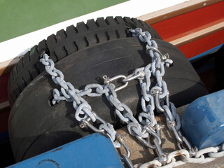 港の桟橋とショック止めの古タイヤをつなぐ鎖