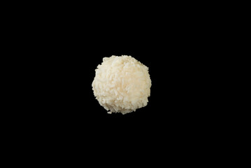 Popular coconut sweets, round white candies in coconut flakes, isolated on a black background