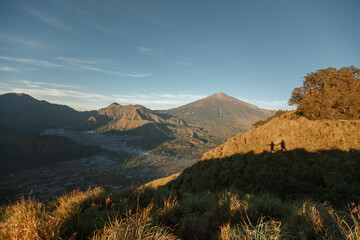 Obraz premium Landscape of Mount Rinjani from Sembalun Village, East Lombok. Couple silhouettes on the grass