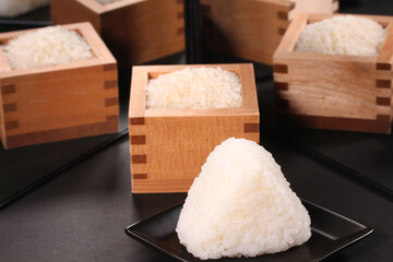 鏡に映るおにぎりと枡に入った米