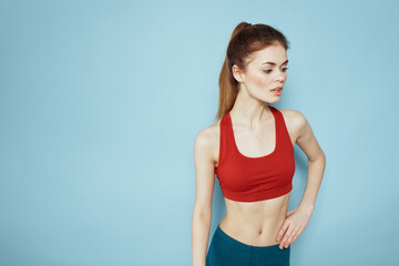 Fototapeta na wymiar Sportive woman red tank top workout lifestyle gym blue background
