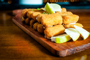 sticks mozzarella sticks with lemon and parsley on a rustic wooden table