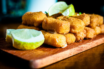 sticks mozzarella sticks with lemon and parsley on a rustic wooden table
