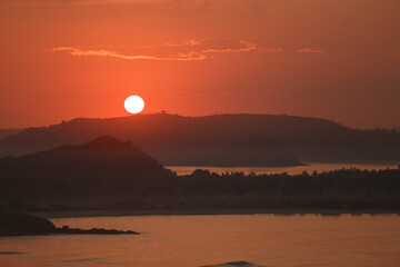 Golden, yellow and orange colors of sunset by the sea. Lombok island, Indonesia. Merese hill view