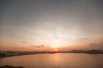 Scenic sunrise view at Merese hill, Lombok island, Indonesia.Beautiful golden sky over the sea behind mountains in background
