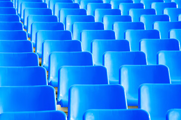 Naklejka premium geometric photo of a set of blue seats on the outdoor grandstand of a sports court
