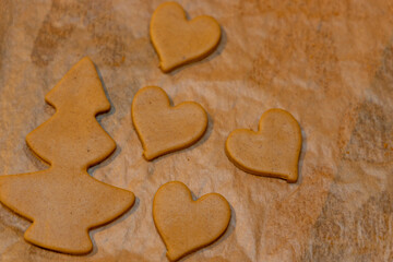 Gingerbread cookies of various shapes on baking paper. Handmade homemade cookies.