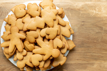 Gingerbread cookies of various shapes on a plate on a wooden table. Homemade handmade cookies. Copy space.