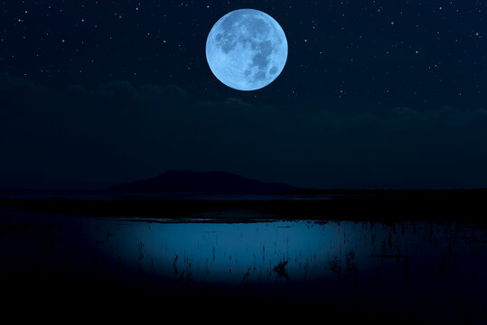 Full moon over lake at night.