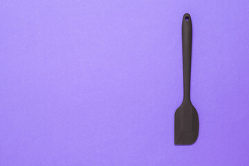 Silicone kitchen spatula on a lilac background.