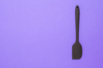 Silicone kitchen spatula on a lilac background.